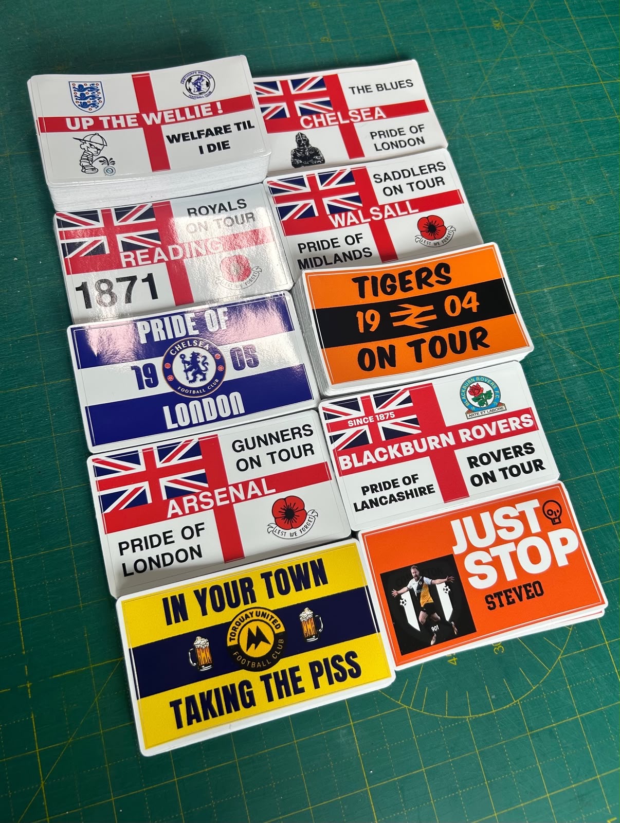 Custom printed football supporter stickers laid out on a cutting mat